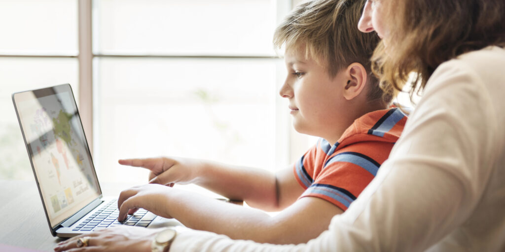 A young boy and his mother on the computer